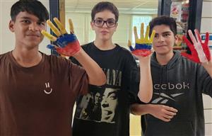 3 boys with hands painted to look like Colombian and Peruvian flags